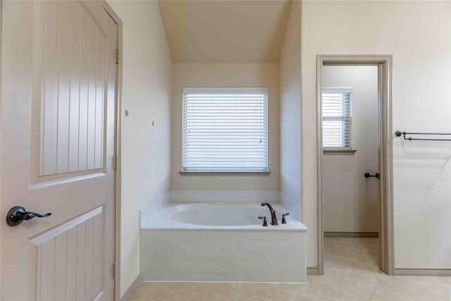 bathroom with a washtub and tile patterned floors