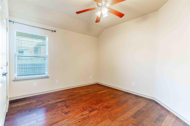 empty room featuring dark wood-type flooring, vaulted ceiling, and ceiling fan