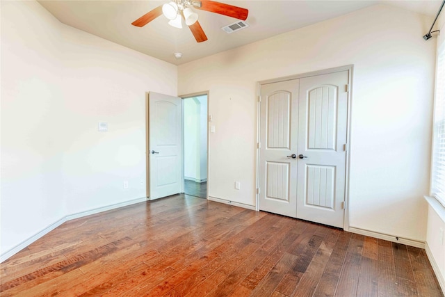 unfurnished bedroom featuring hardwood / wood-style flooring, a closet, and ceiling fan