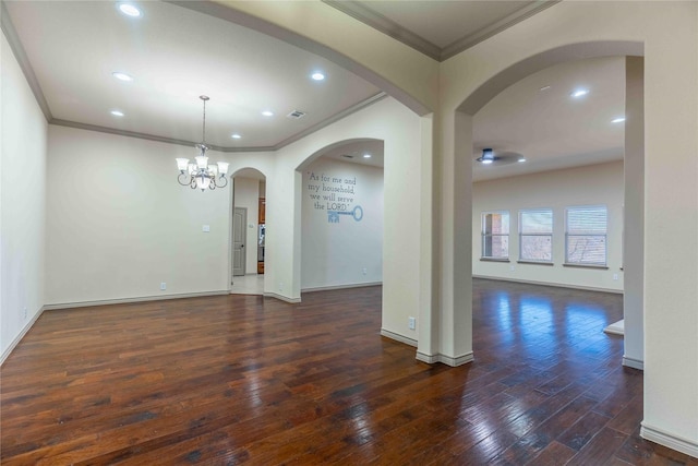 empty room featuring a chandelier, ornamental molding, and dark hardwood / wood-style floors