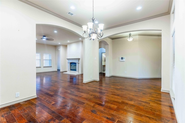 unfurnished living room featuring a notable chandelier, ornamental molding, and dark hardwood / wood-style floors