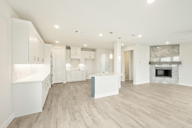 kitchen with visible vents, open floor plan, recessed lighting, white cabinetry, and a sink