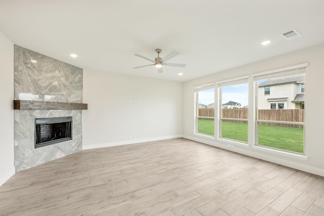 unfurnished living room with baseboards, ceiling fan, wood finished floors, and a fireplace
