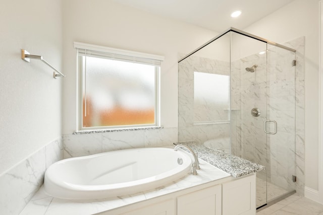 full bathroom with marble finish floor, a marble finish shower, and a garden tub