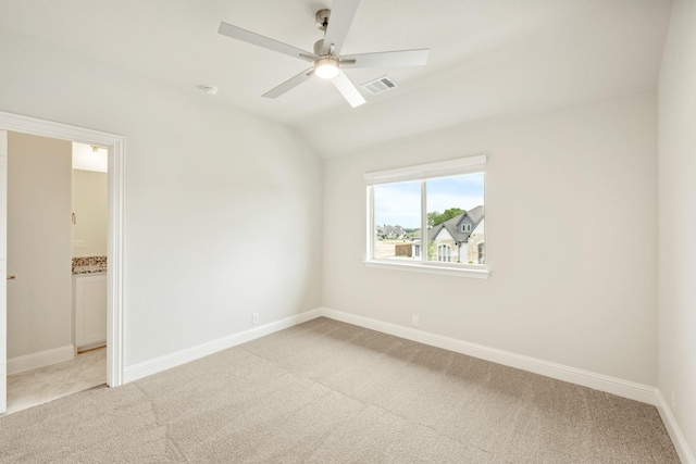 unfurnished bedroom with baseboards, visible vents, light carpet, and vaulted ceiling