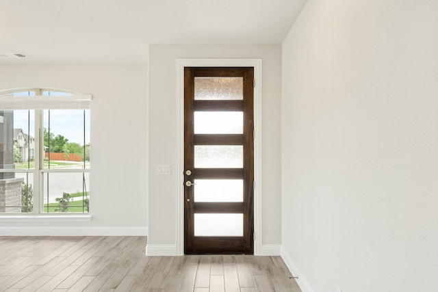 entryway with visible vents, light wood-style flooring, and baseboards