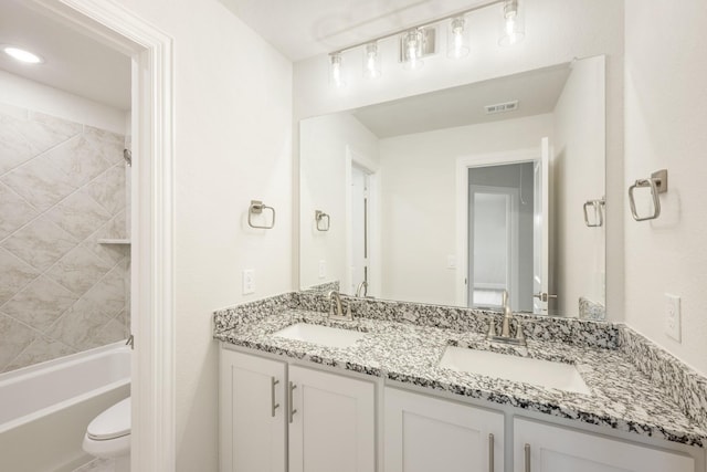 bathroom featuring visible vents, a sink, double vanity, and toilet