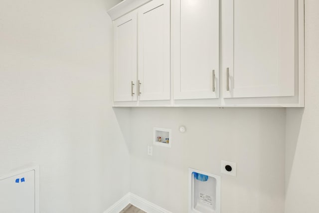 clothes washing area with baseboards, gas dryer hookup, electric dryer hookup, cabinet space, and washer hookup