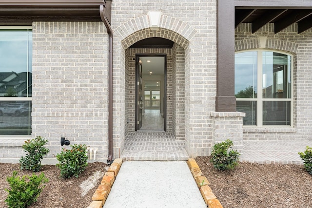 entrance to property featuring brick siding
