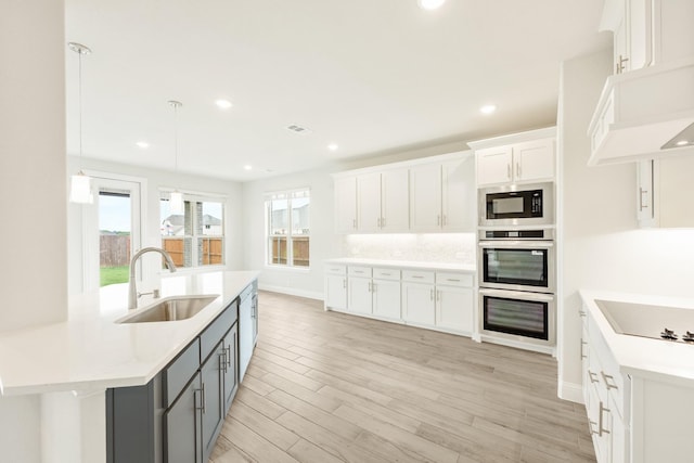 kitchen with a sink, light countertops, gray cabinets, white cabinetry, and black appliances