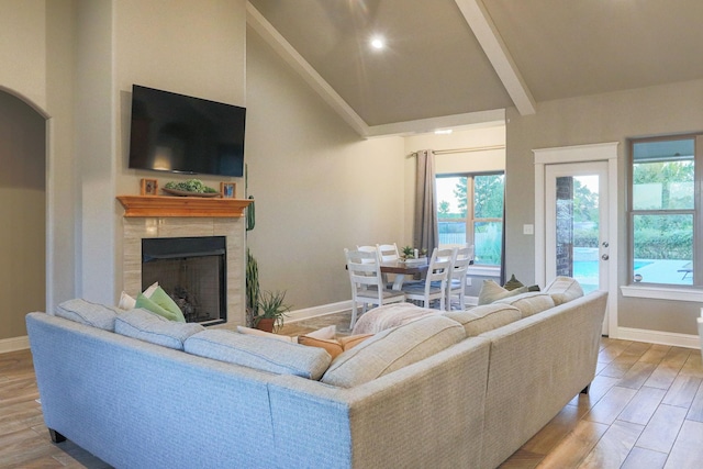 living room featuring a tile fireplace and lofted ceiling