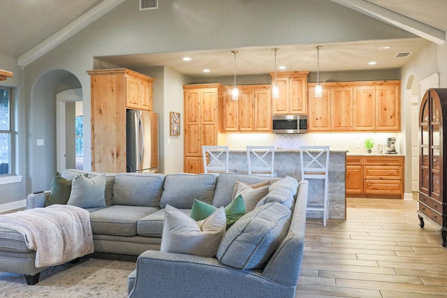 living room featuring lofted ceiling with beams and light wood-type flooring