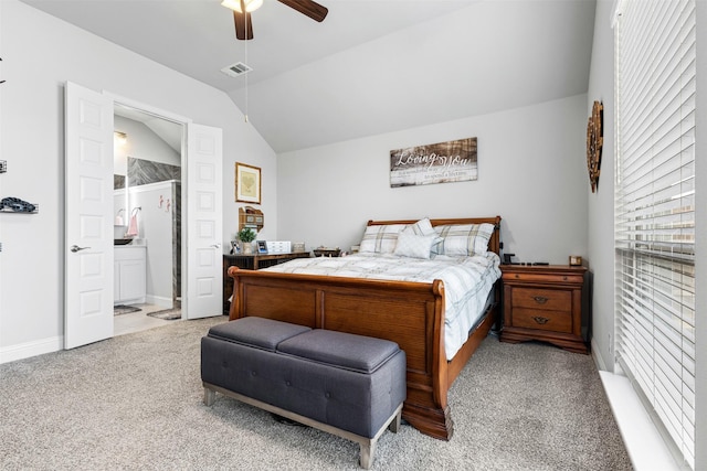 bedroom with ceiling fan, light carpet, lofted ceiling, and ensuite bathroom