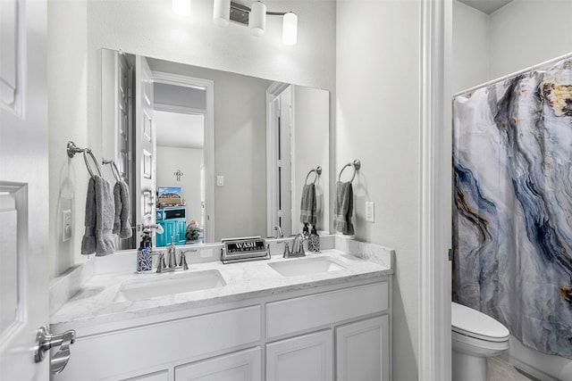 full bath with double vanity, a sink, toilet, and shower / bath combo with shower curtain