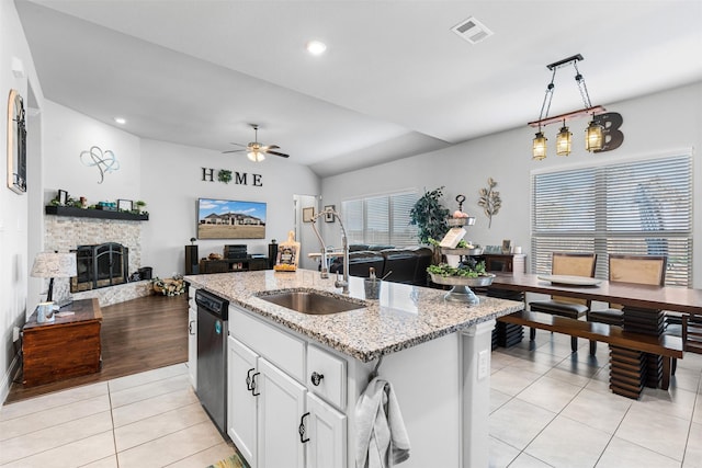 kitchen featuring dishwasher, hanging light fixtures, white cabinets, light tile patterned flooring, and an island with sink