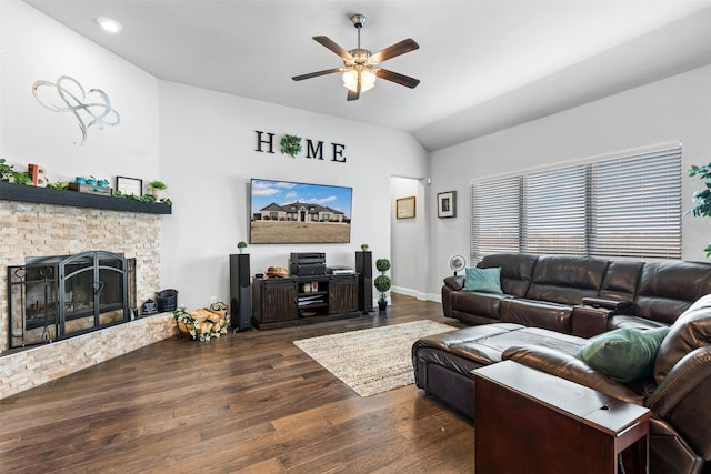 living room with ceiling fan, vaulted ceiling, dark wood-type flooring, and a fireplace