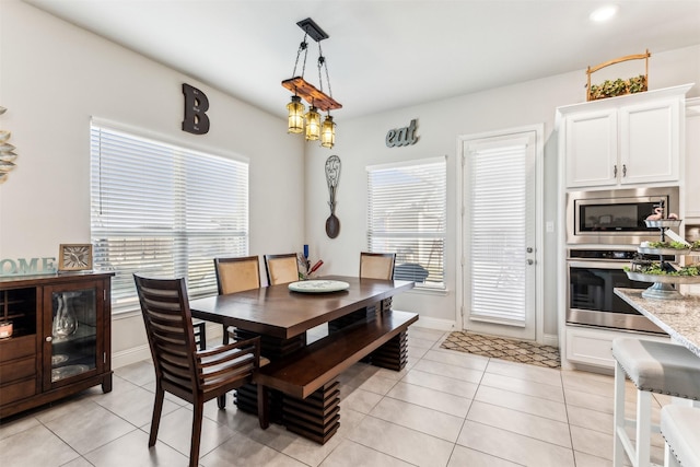 dining area featuring light tile patterned floors and baseboards