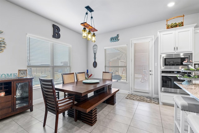 dining space featuring light tile patterned floors and baseboards