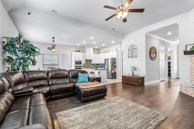 living room featuring ceiling fan, crown molding, and dark hardwood / wood-style floors