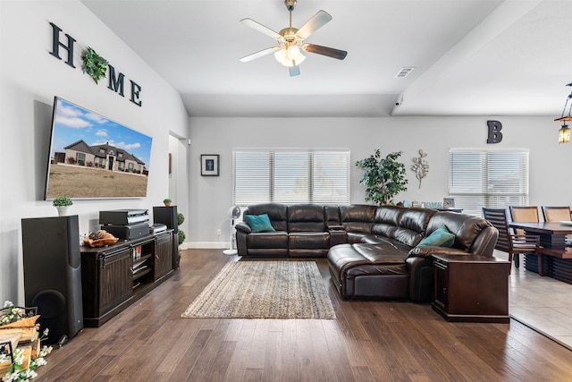 living room with baseboards, dark wood finished floors, visible vents, and a ceiling fan