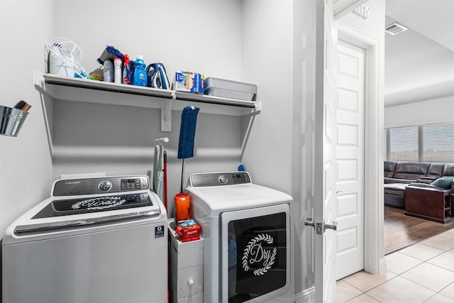 clothes washing area featuring independent washer and dryer and light tile patterned floors