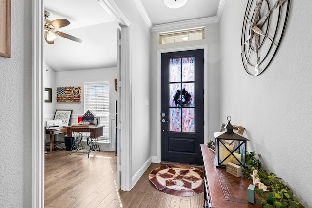 foyer entrance featuring ceiling fan, hardwood / wood-style flooring, a wealth of natural light, and ornamental molding