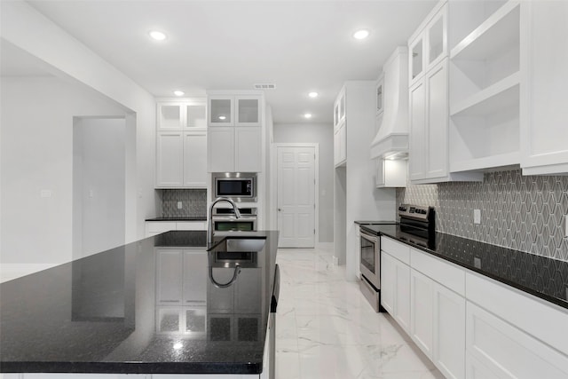 kitchen featuring sink, white cabinets, dark stone counters, decorative backsplash, and stainless steel appliances