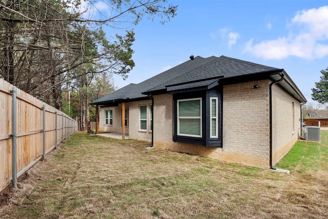 rear view of property with a yard, central AC, and a patio