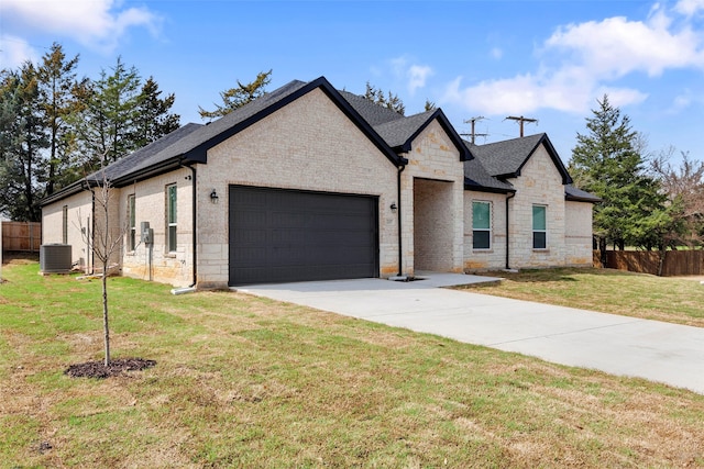 view of front of property with a garage, central AC unit, and a front lawn