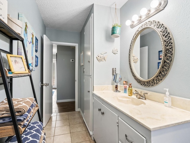 bathroom with a textured ceiling, vanity, and tile patterned flooring