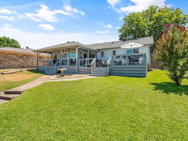 rear view of house featuring a deck and a lawn