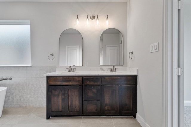 bathroom with a washtub, tile patterned floors, and vanity