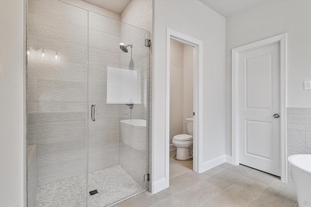 bathroom featuring tile patterned flooring, toilet, and shower with separate bathtub