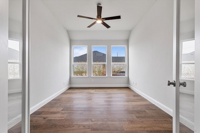 spare room featuring a mountain view, dark wood-type flooring, lofted ceiling, and ceiling fan