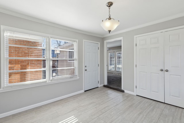 entryway with ornamental molding and light hardwood / wood-style flooring