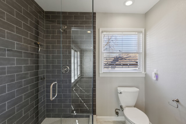 bathroom with a shower with door and toilet