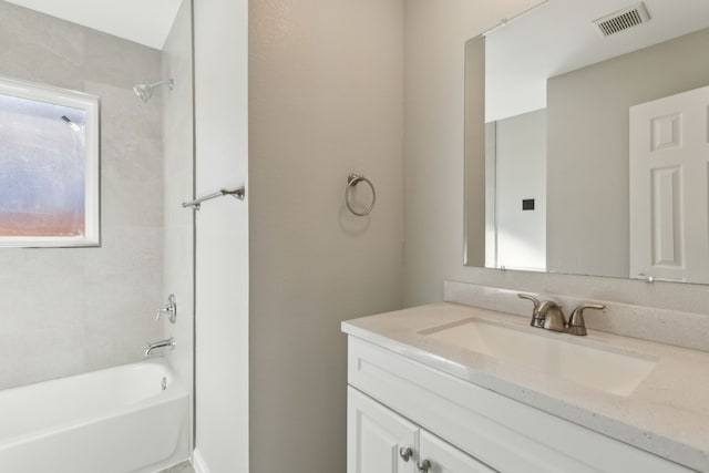 bathroom with tiled shower / bath and vanity