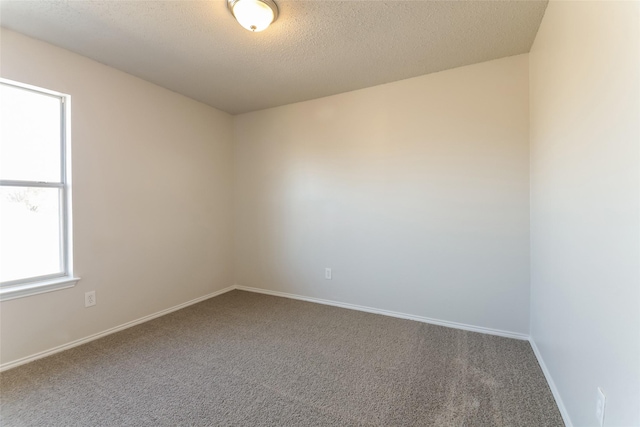 carpeted spare room featuring a textured ceiling