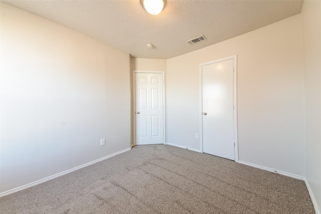 unfurnished bedroom with a textured ceiling and carpet flooring