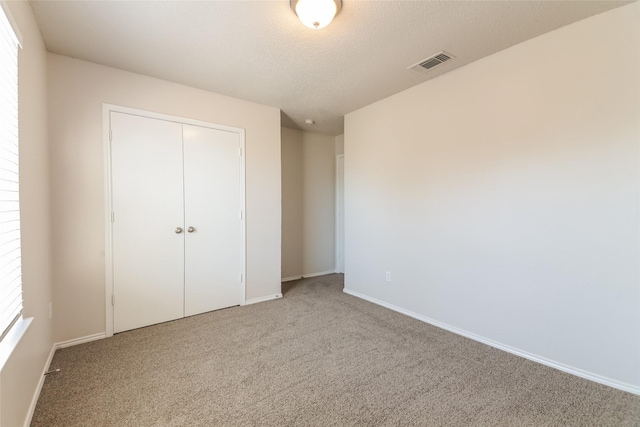 unfurnished bedroom with a closet and carpet floors