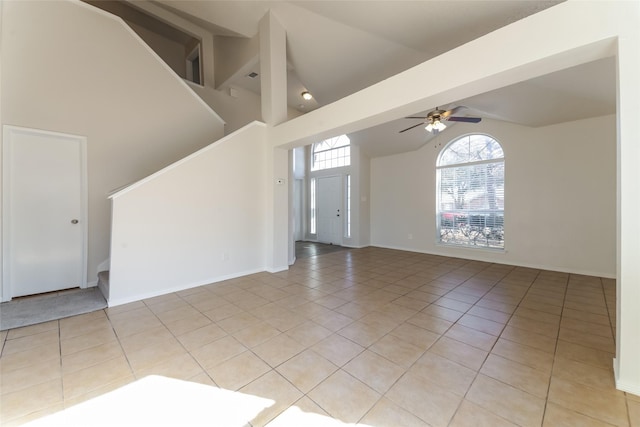 tiled empty room with high vaulted ceiling and ceiling fan