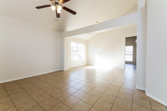 tiled empty room with vaulted ceiling and ceiling fan