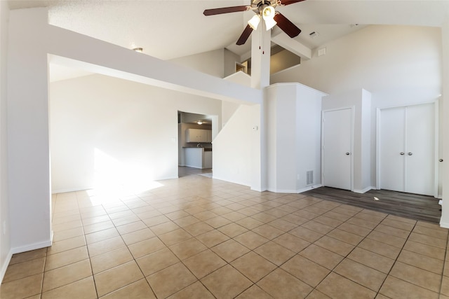 spare room with ceiling fan, high vaulted ceiling, and light tile patterned floors