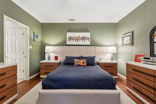 bedroom featuring baseboards, dark wood-type flooring, visible vents, and crown molding