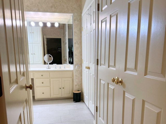 bathroom with wallpapered walls and vanity