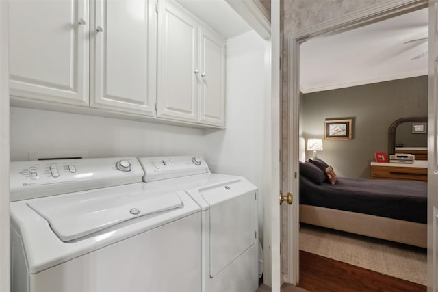 laundry room with ornamental molding, washer and clothes dryer, and cabinet space