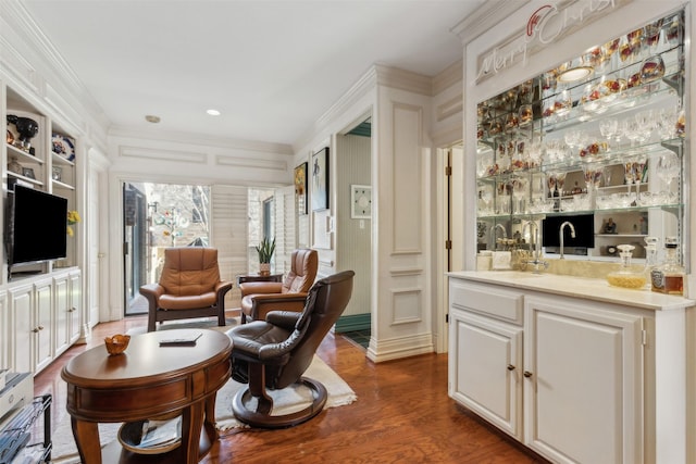 interior space featuring ornamental molding, wet bar, and dark wood-style flooring