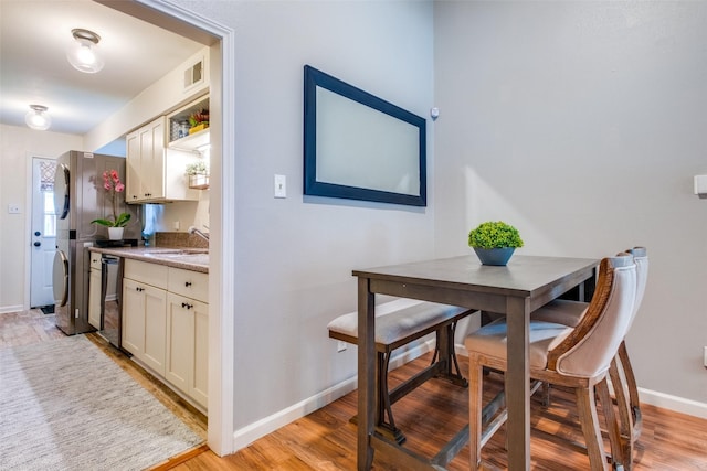 dining area with sink and light wood-type flooring