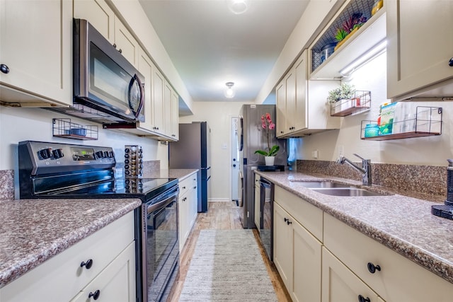 kitchen featuring stainless steel electric range oven, sink, light wood-type flooring, and dishwasher