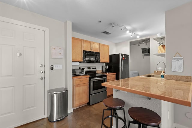 kitchen featuring sink, kitchen peninsula, stainless steel appliances, a breakfast bar area, and light brown cabinets